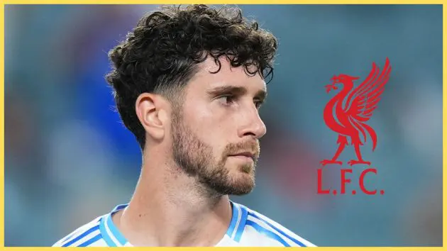 Bournemouth defender Marcos Senesi looks at Liverpool logo.