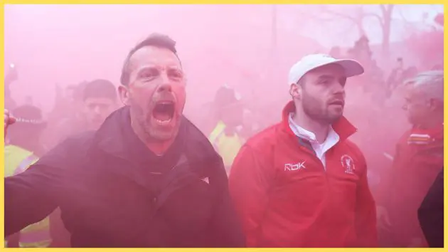 Liverpool fans march in red smoke ahead of PSG game.